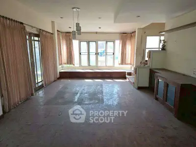 Spacious living room with large windows and natural light, ideal for modern living.