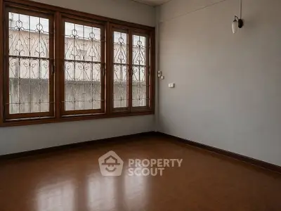 Spacious empty room with large windows and wooden flooring, perfect for customization.