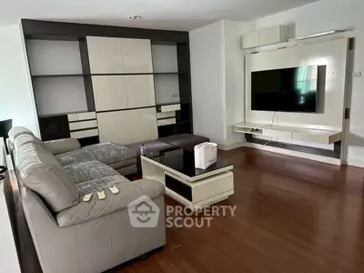 Modern living room with sleek furniture and wall-mounted TV, perfect for relaxation and entertainment.