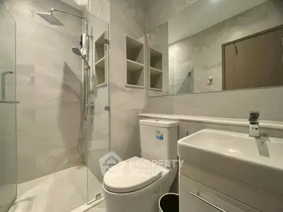 Modern bathroom with sleek fixtures and glass shower enclosure.