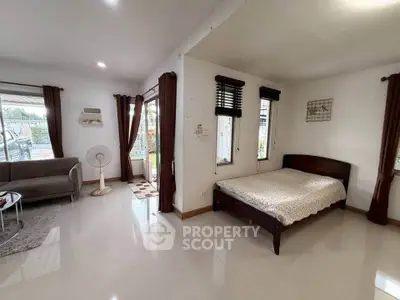 Spacious open-plan bedroom with large windows and modern decor