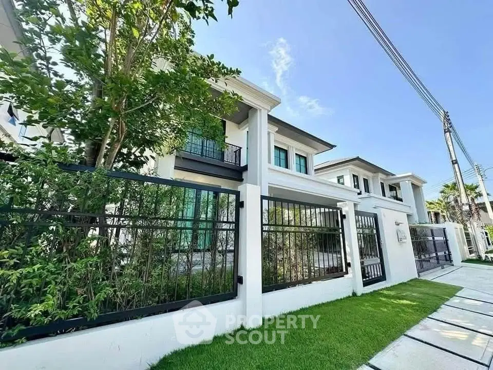 Luxurious modern house exterior with lush garden and elegant fence