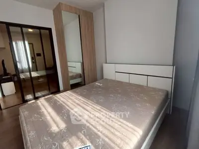 Modern bedroom with stylish wardrobe and large mirror reflecting natural light.