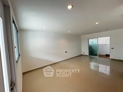 Spacious empty room with glossy tiled floor and modern lighting, ideal for customization.