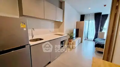 Modern studio apartment with sleek kitchen and cozy living area, perfect for urban living.