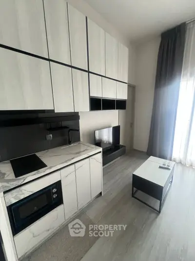 Modern minimalist kitchen with sleek cabinetry and integrated appliances in a stylish apartment.