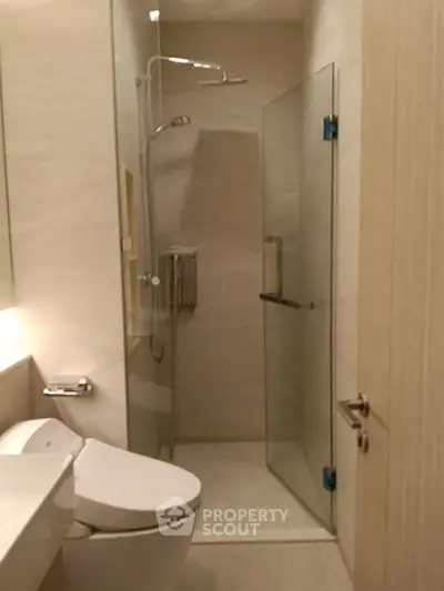 Modern bathroom with glass shower and sleek fixtures in a contemporary apartment.