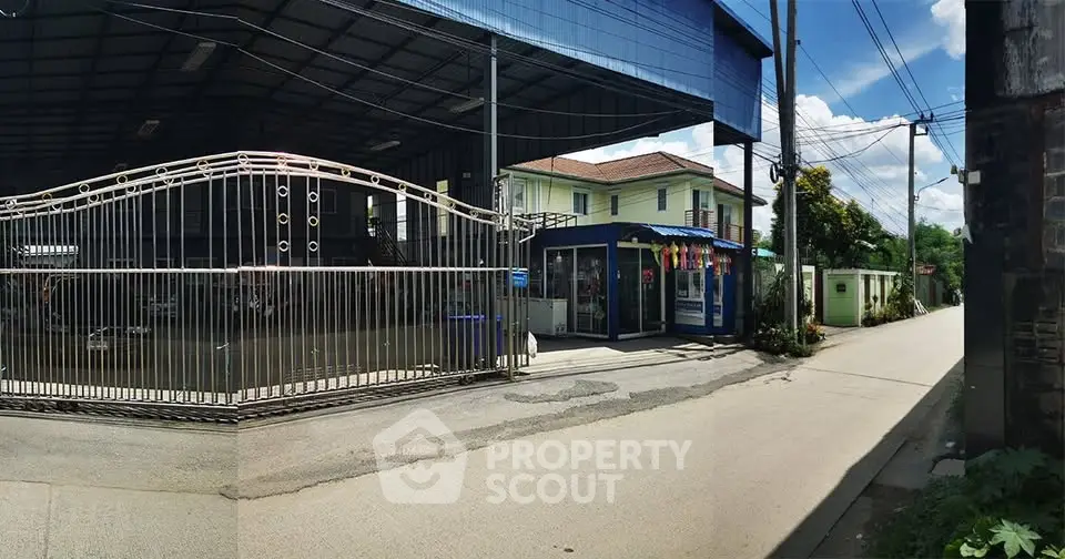 Industrial property with large gated entrance and adjacent residential building