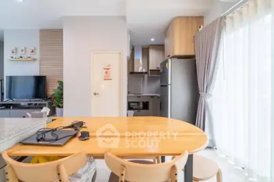 Modern open-layout kitchen and dining area with natural light and stylish decor.