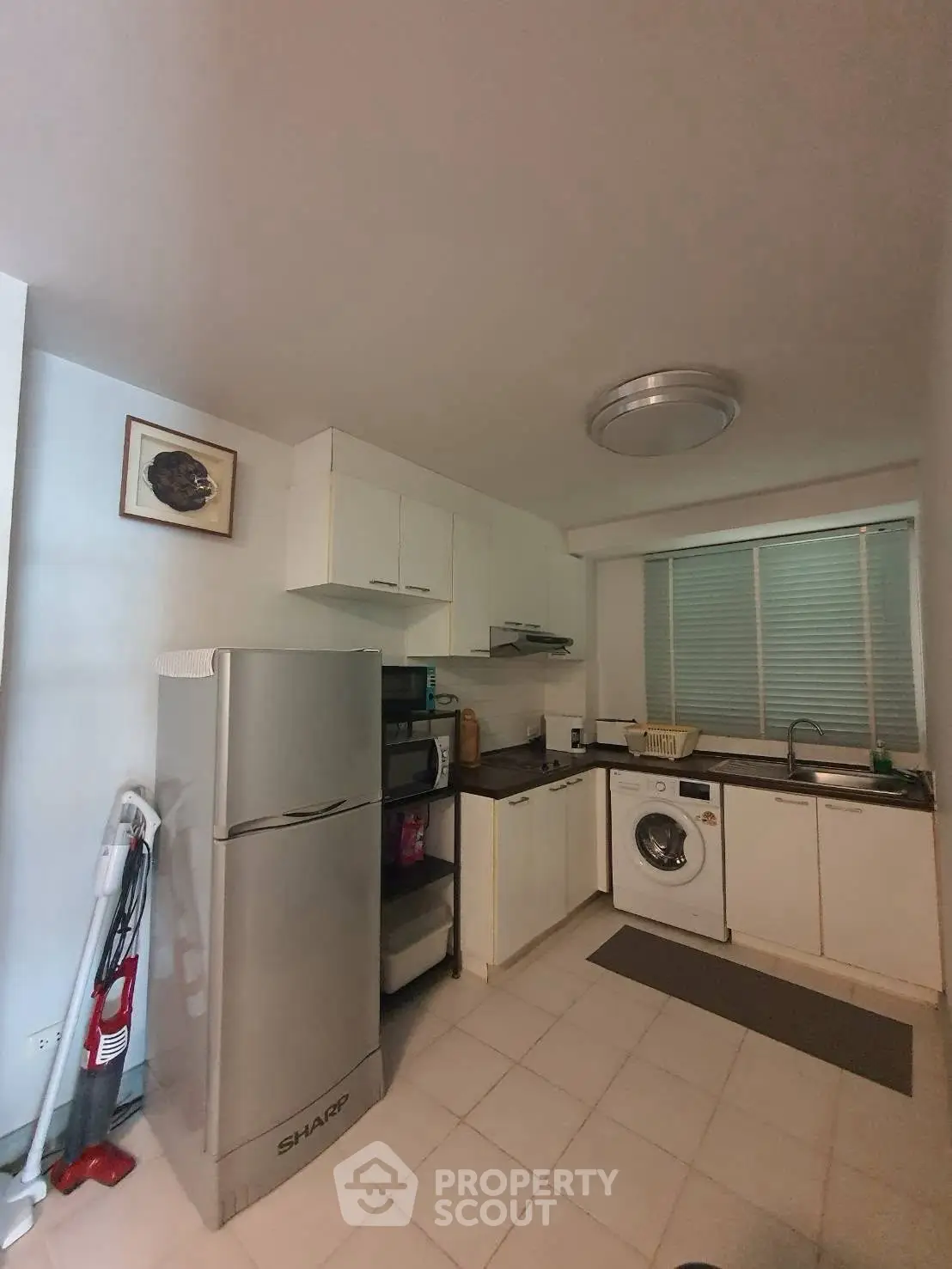 Cozy kitchen with modern appliances and washing machine in a compact layout.
