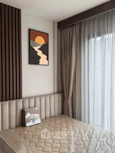 Modern bedroom with stylish decor and large window for natural light.