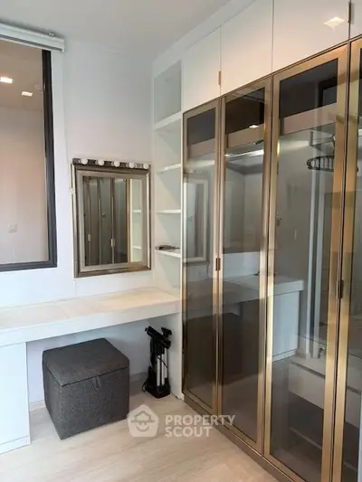 Modern storage room with sleek glass cabinets and vanity mirror