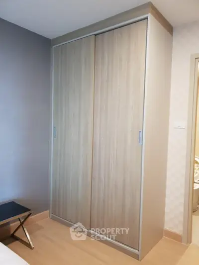 Modern bedroom with sleek wooden wardrobe and minimalist decor