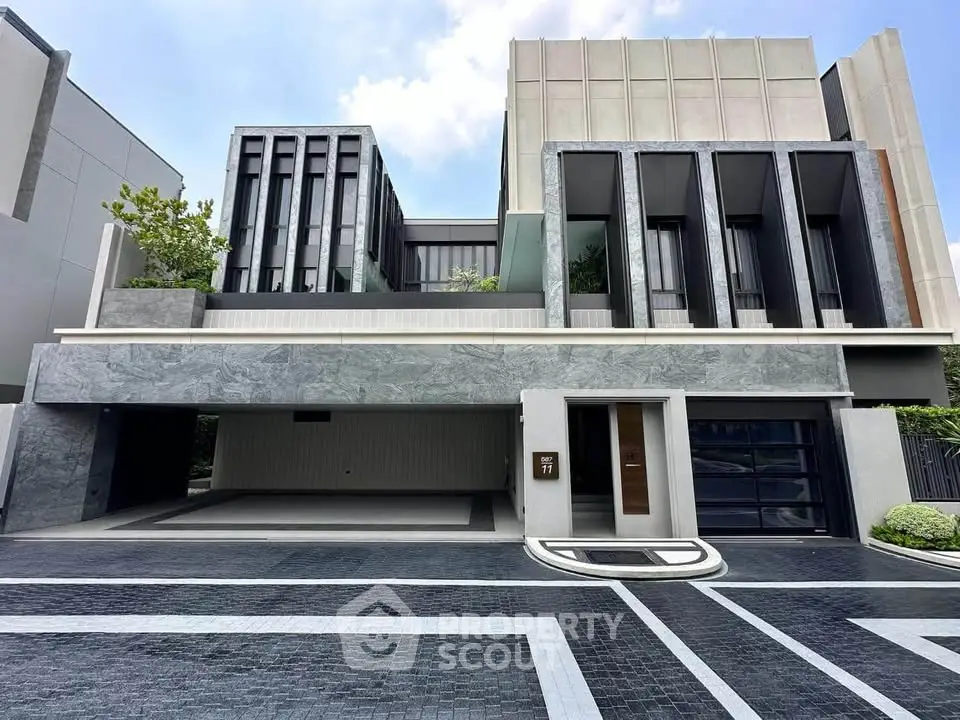 Luxurious modern home exterior with sleek design and spacious driveway, showcasing contemporary architecture.