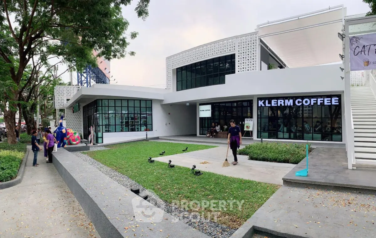 Modern coffee shop exterior with sleek design and green landscaping