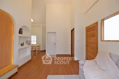 Spacious modern living room with wooden flooring and cozy seating area.