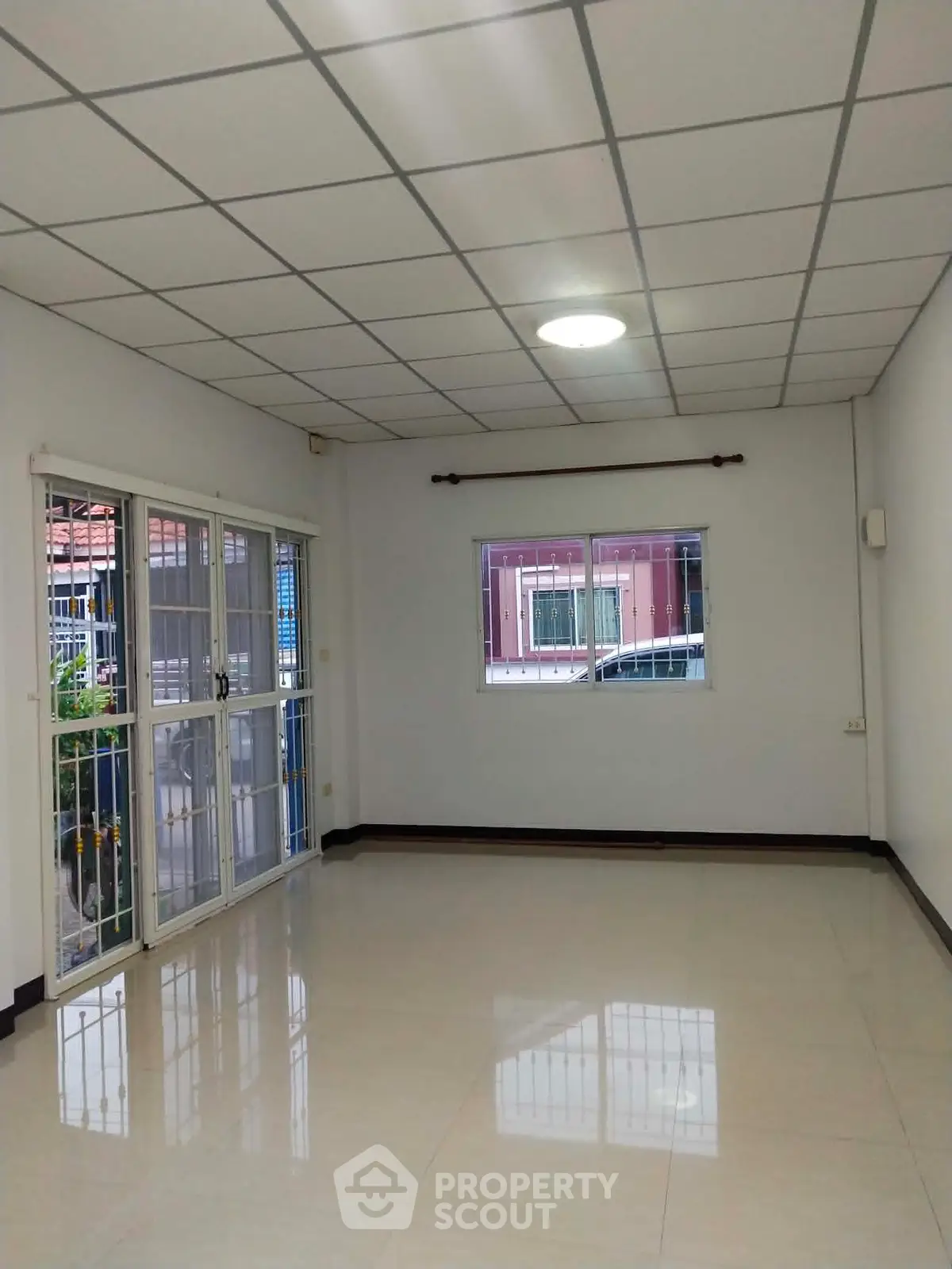 Spacious empty room with large windows and tiled floor, perfect for customization.