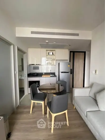 Modern open-plan living room with sleek kitchen and stylish furniture in a contemporary apartment.