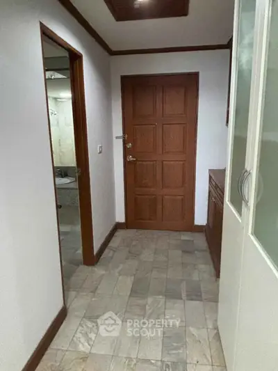 Charming hallway with wooden door and tiled floor in cozy apartment