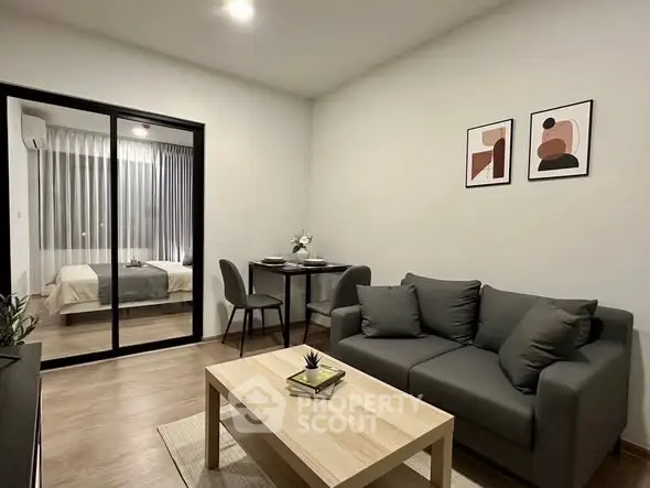 Modern living room with cozy sofa and stylish decor adjacent to a bedroom.