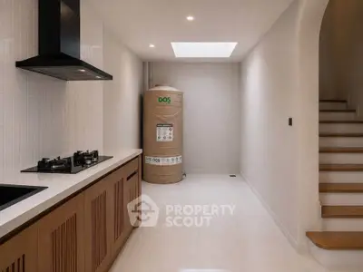 Modern kitchen with gas stove and storage tank, featuring sleek wooden cabinetry and bright lighting.