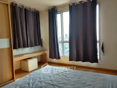 Spacious bedroom with large windows and city view, featuring modern curtains and a sleek wooden wardrobe.