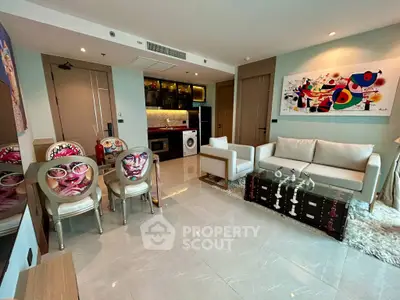 Modern living room with stylish decor and open kitchen layout, featuring unique art and sleek furniture.