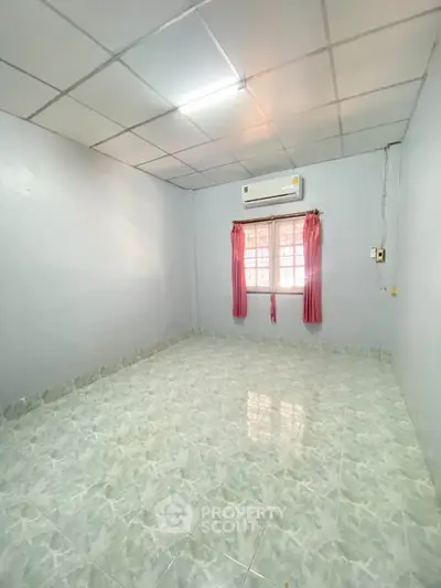 Spacious unfurnished room with tiled flooring and air conditioning, ideal for customization.