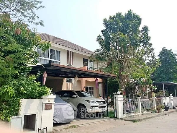 Charming suburban house with carport and lush greenery in a peaceful neighborhood.
