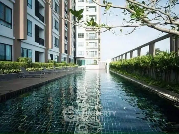Luxurious apartment building with a serene outdoor pool and lush greenery.