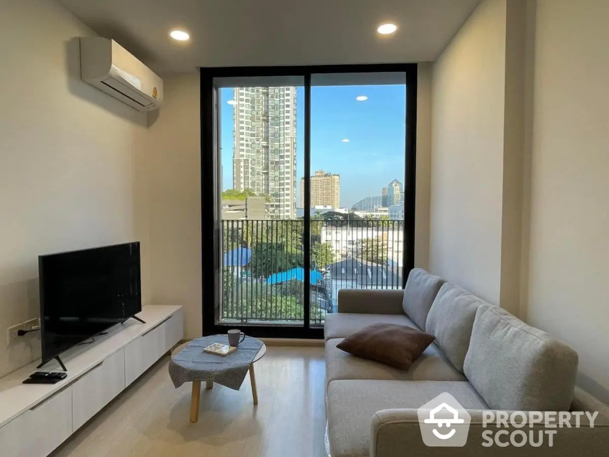 Modern living room with large window offering city view, stylish sofa, and sleek TV setup.