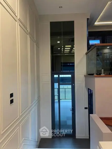 Elegant modern home entrance with high ceilings and glass door