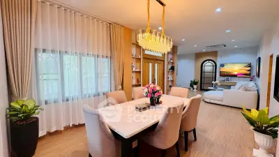 Luxurious open-plan living and dining area with elegant chandelier and modern decor.