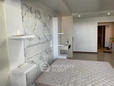 Spacious modern bedroom with marble accent wall and minimalist design