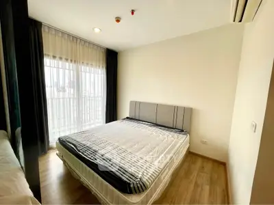Modern bedroom with large window and stylish decor in a contemporary apartment.