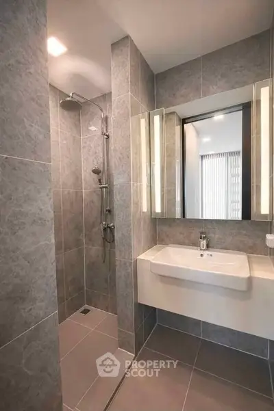 Modern bathroom with sleek gray tiles and a spacious walk-in shower