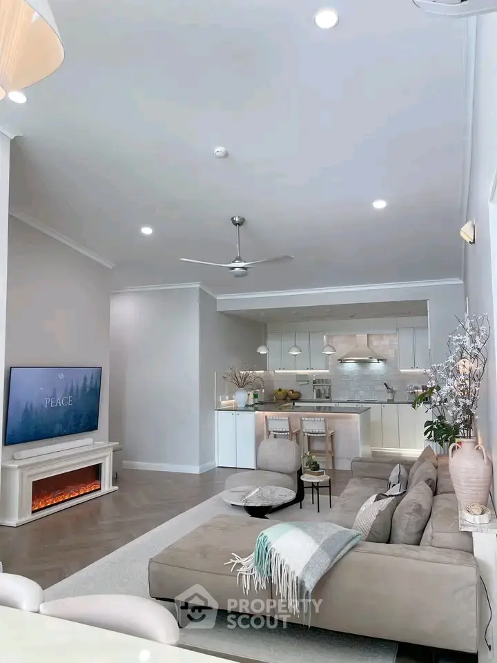 Modern living room with open kitchen, cozy fireplace, and elegant decor