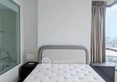 Modern bedroom with large window and city view, featuring a comfortable bed and stylish decor.