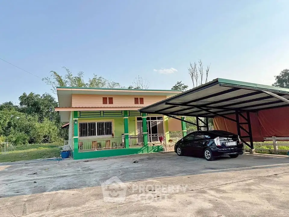 Charming single-story home with carport and spacious driveway in a serene green setting.