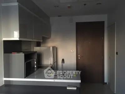 Modern kitchen with sleek cabinetry and stainless steel appliances in a stylish apartment.