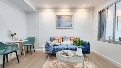 Stylish modern living room with blue sofa, chic decor, and cozy ambiance