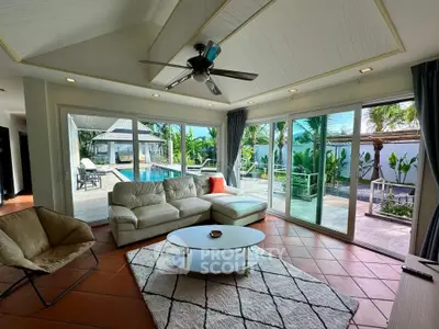 Spacious living room with pool view and modern decor in luxury home