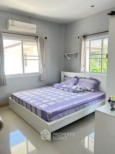 Bright and cozy bedroom with large windows and modern decor