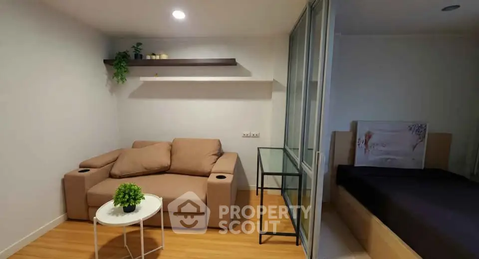 Cozy living room with modern decor and adjacent bedroom in stylish apartment.