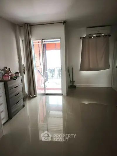 Spacious bedroom with glossy tiled floor and balcony access, perfect for natural light lovers.