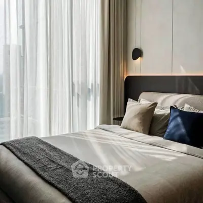 Luxurious bedroom with modern decor and natural light through sheer curtains.