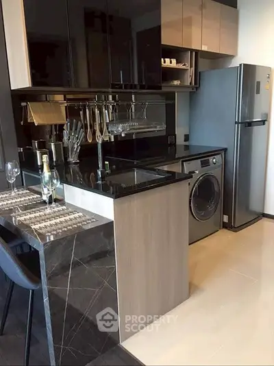 Modern kitchen with sleek appliances and stylish breakfast bar in a contemporary apartment.