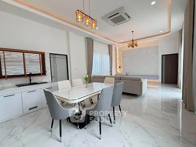 Luxurious open-plan living and dining area with elegant decor and modern lighting.