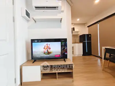 Modern living room with TV and compact kitchen in stylish apartment