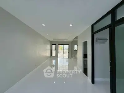 Spacious modern living room with glossy white floors and large windows.